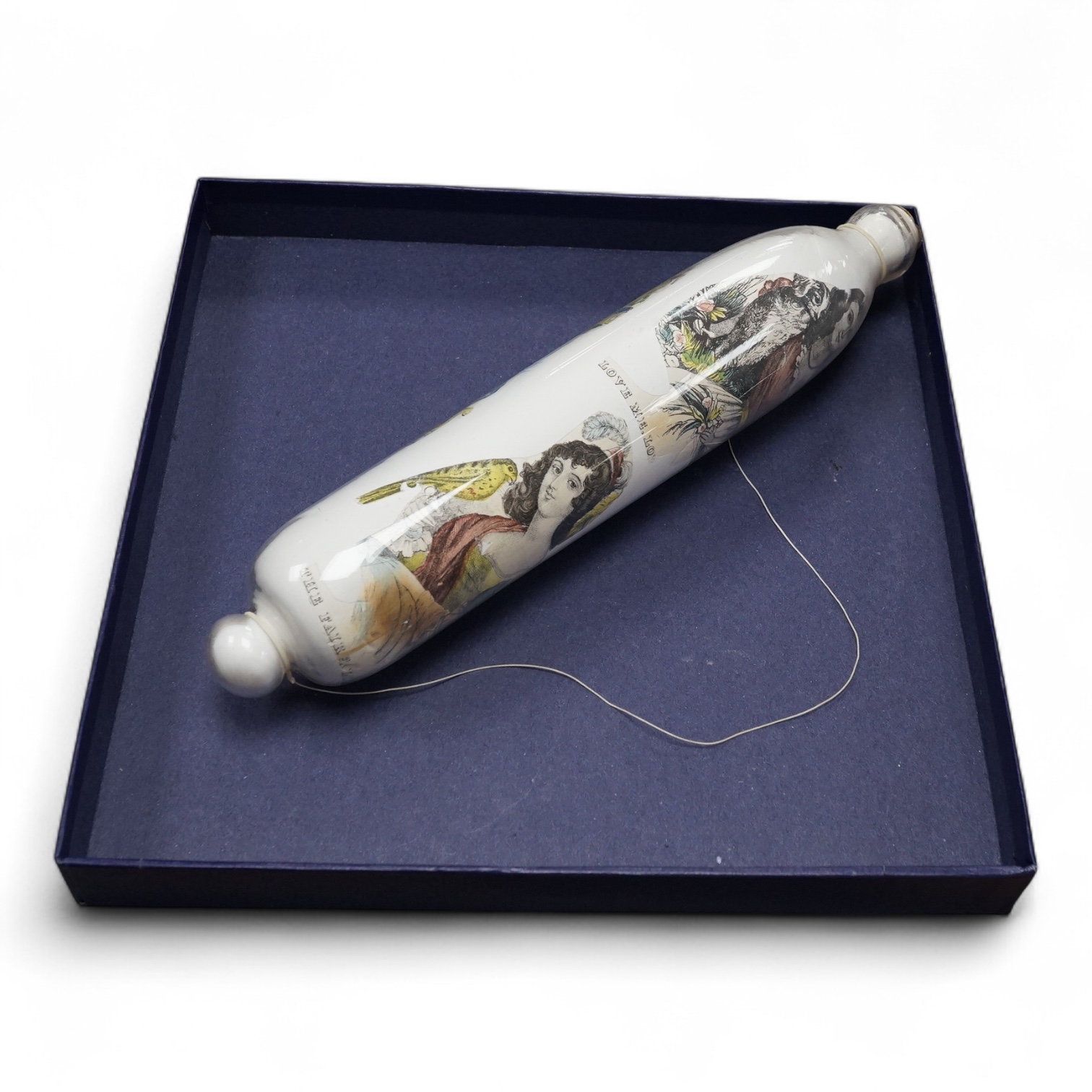 A Nailsea-type glass rolling pin, with transfer printed decoration. 33cm long. Condition - good